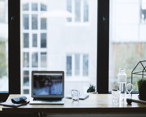 Clear glass of water on a desk near a window